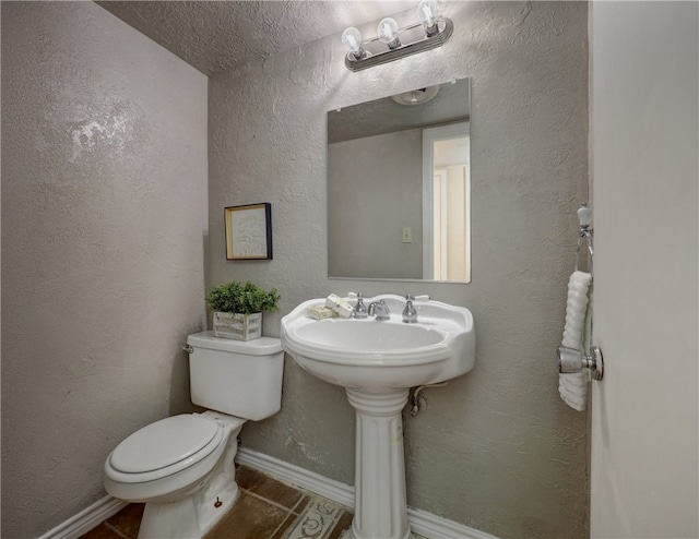 bathroom featuring toilet, a textured ceiling, and tile patterned floors