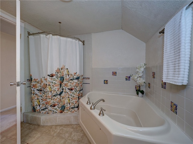 bathroom with tile walls, separate shower and tub, a textured ceiling, tile patterned flooring, and lofted ceiling