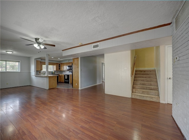 unfurnished living room featuring dark hardwood / wood-style flooring, a textured ceiling, and ceiling fan