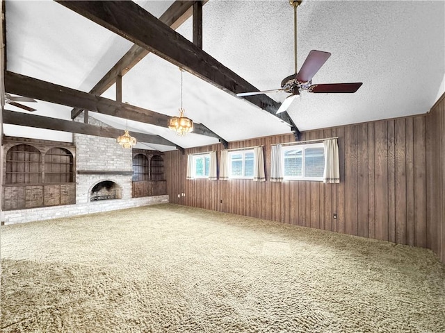 unfurnished living room with a textured ceiling, carpet, ceiling fan, and wooden walls