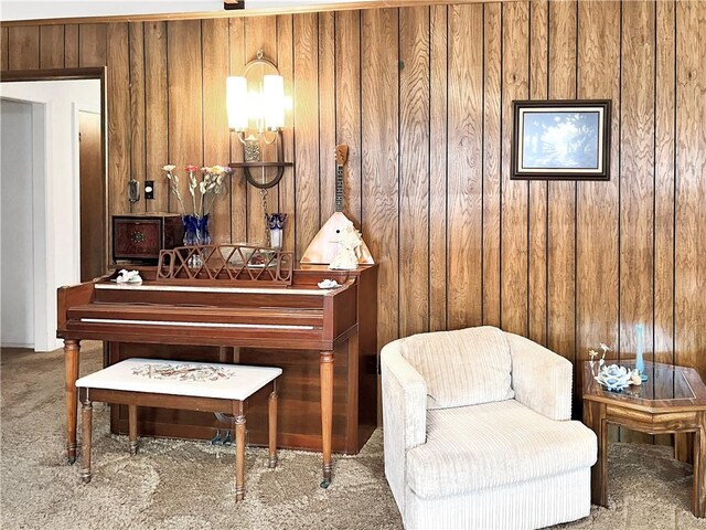 living area featuring carpet floors and wood walls