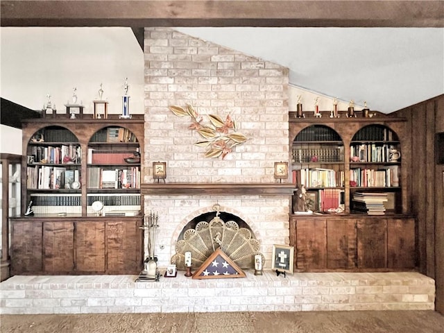 interior space featuring built in features and vaulted ceiling with beams