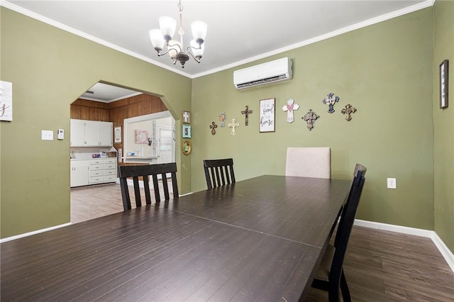1009 E Sinton St, Sinton, TX 78387 - dining room featuring a wall mounted AC, a chandelier, wood finished floors, arched walkways, and crown molding