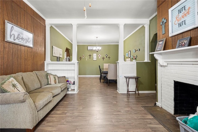 1009 E Sinton St, Sinton, TX 78387 - living room with wood finished floors, a chandelier, crown molding, a brick fireplace, and baseboards