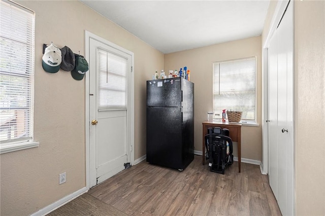 1009 E Sinton St, Sinton, TX 78387 - kitchen featuring freestanding refrigerator, wood finished floors, and baseboards