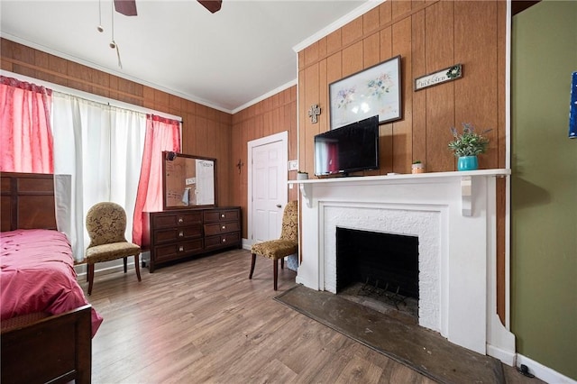 1009 E Sinton St, Sinton, TX 78387 - living room featuring crown molding, a ceiling fan, wood finished floors, a fireplace with flush hearth, and wood walls