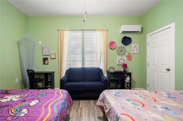 1009 E Sinton St, Sinton, TX 78387 - bedroom with a wall mounted AC and wood finished floors