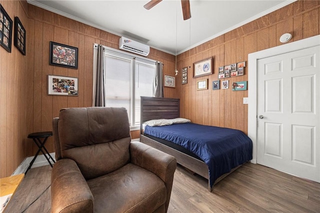 1009 E Sinton St, Sinton, TX 78387 - bedroom with a wall mounted AC, wood finished floors, ornamental molding, wooden walls, and a ceiling fan