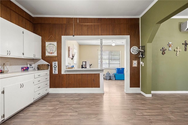 1009 E Sinton St, Sinton, TX 78387 - kitchen with light countertops, ornamental molding, white cabinetry, light wood-type flooring, and baseboards