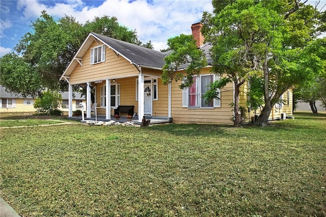 1009 E Sinton St, Sinton, TX 78387 - view of front of house with a porch, a chimney, and a front lawn