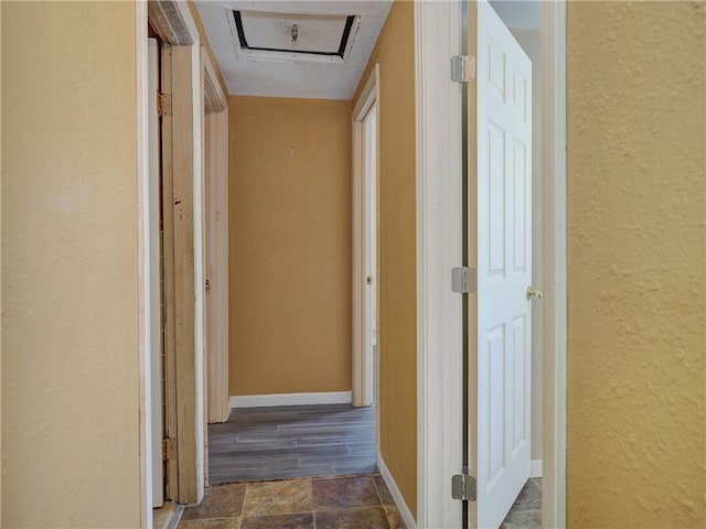 corridor with a textured wall and baseboards