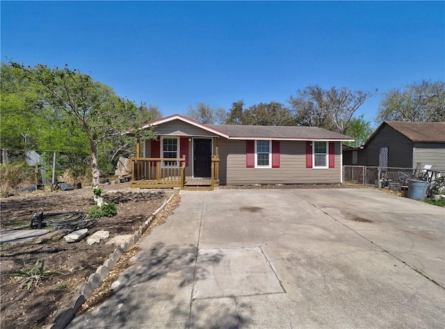 view of front of home with concrete driveway and fence