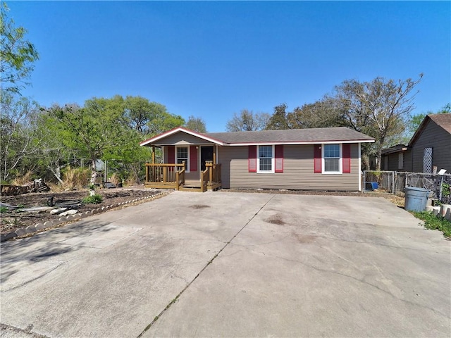 view of front of house with concrete driveway and fence