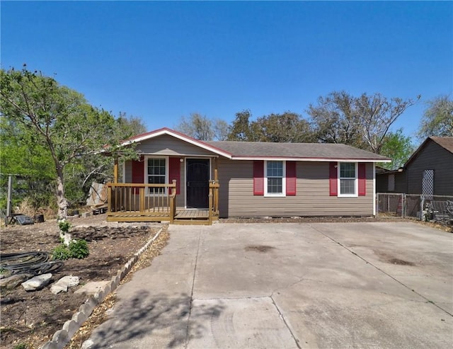 ranch-style house featuring a porch and fence