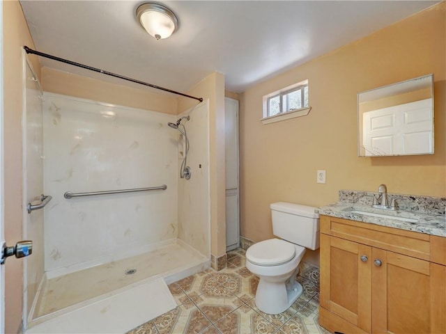 bathroom featuring tile patterned floors, toilet, vanity, and walk in shower