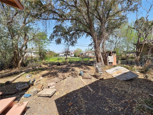 view of yard featuring a storage shed, an outdoor structure, and fence