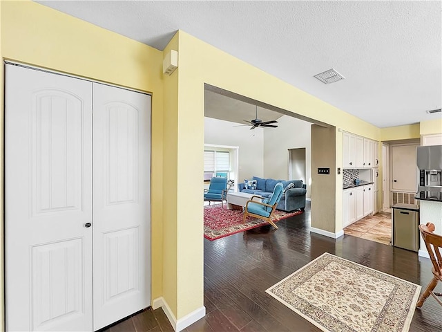 hallway featuring a textured ceiling and dark hardwood / wood-style flooring