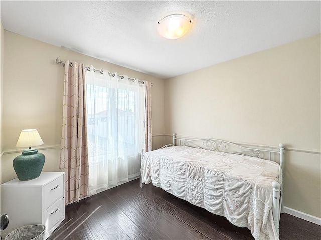 bedroom with dark wood-type flooring and a textured ceiling