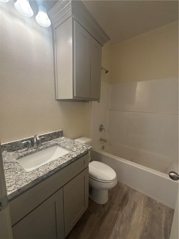 3101 Adak Ct, Corpus Christi, TX 78414 - bathroom featuring toilet, wood finished floors, vanity, and bathtub / shower combination
