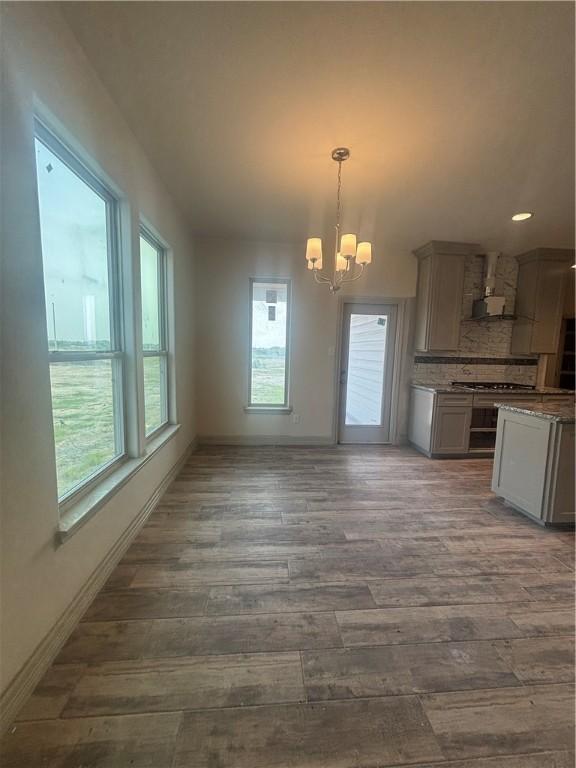3101 Adak Ct, Corpus Christi, TX 78414 - unfurnished dining area with dark wood finished floors, a chandelier, and baseboards