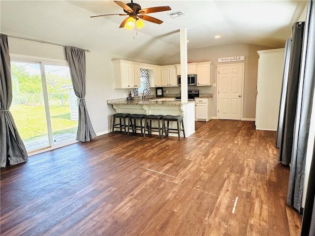 2514 Dwyer Dr, Corpus Christi, TX 78410 - kitchen featuring stainless steel microwave, range, a peninsula, a kitchen breakfast bar, and lofted ceiling