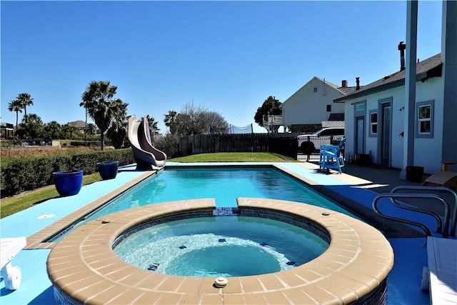 view of pool with a pool with connected hot tub, a fenced backyard, a water slide, and a patio area