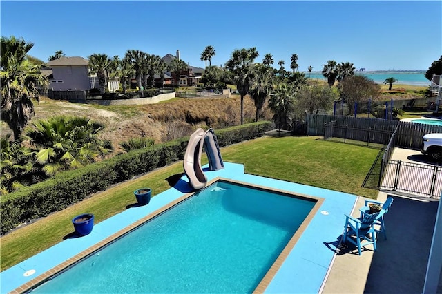 view of pool with a water view, a lawn, fence, a water slide, and a patio area