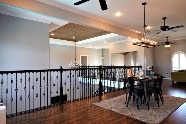 dining space with ornamental molding, ceiling fan with notable chandelier, recessed lighting, wood-type flooring, and a raised ceiling