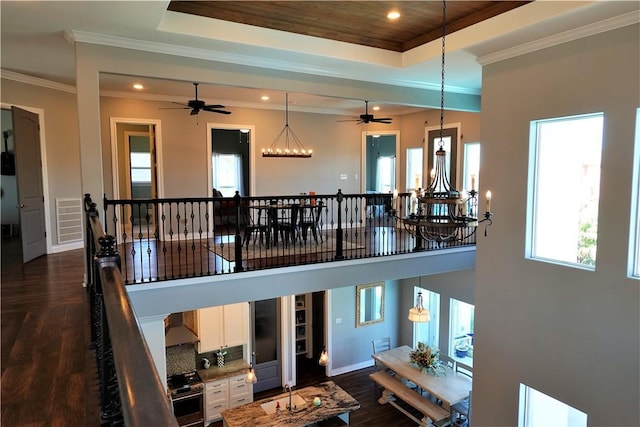 living room featuring visible vents, a notable chandelier, a tray ceiling, dark wood-style floors, and crown molding