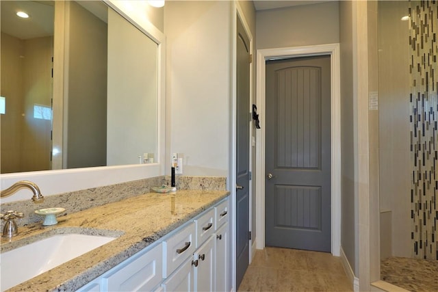 full bath with tile patterned flooring, vanity, and a tile shower