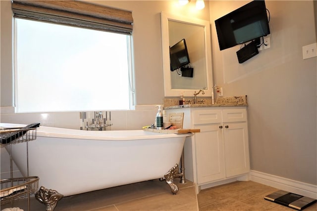 bathroom with tile patterned flooring, vanity, and a freestanding tub