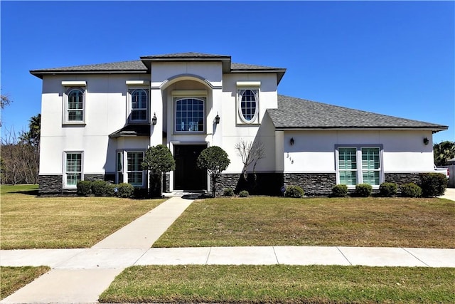 view of front facade with stone siding, stucco siding, a shingled roof, and a front lawn