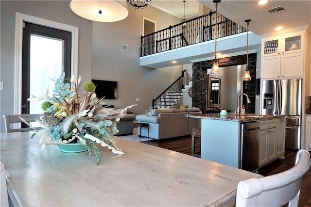 dining room featuring visible vents, a healthy amount of sunlight, and stairway