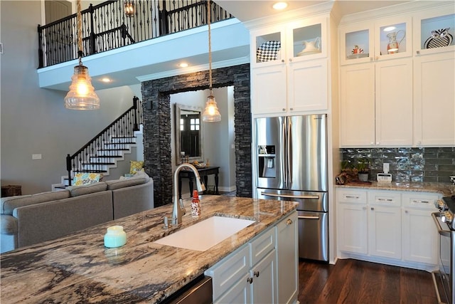 kitchen with dark wood finished floors, open floor plan, appliances with stainless steel finishes, and a sink