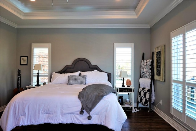 bedroom featuring dark wood-style floors, baseboards, crown molding, and a tray ceiling