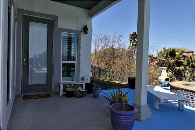 view of patio featuring an in ground hot tub and fence