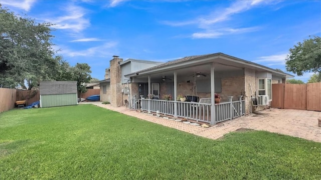 5301 Bromley Dr, Corpus Christi, TX 78413 - back of house featuring ceiling fan, a fenced backyard, a storage shed, a patio, and a chimney