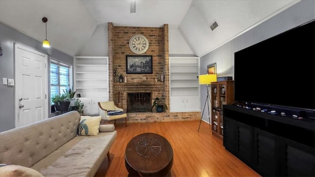 5301 Bromley Dr, Corpus Christi, TX 78413 - living area with wood finished floors, built in shelves, lofted ceiling, and a brick fireplace