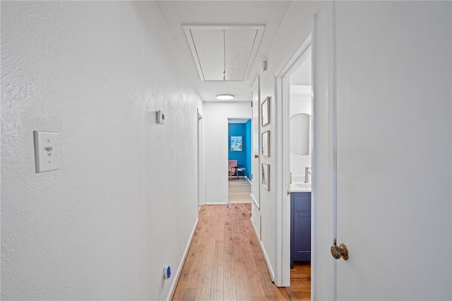 6622 Pharaoh Dr, Corpus Christi, TX 78412 - hallway with attic access, light wood finished floors, and a textured wall