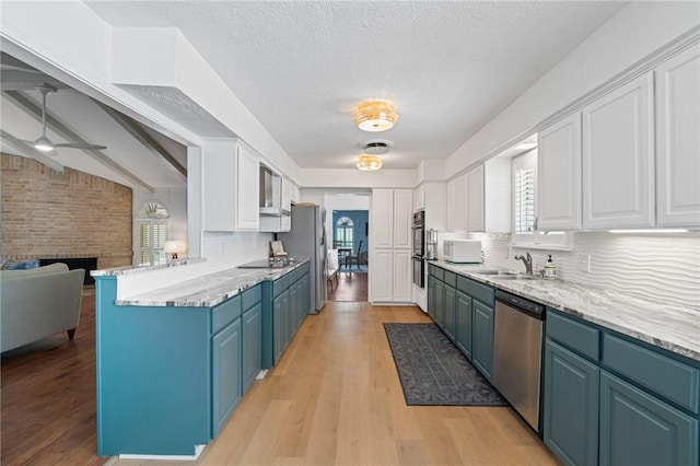 6622 Pharaoh Dr, Corpus Christi, TX 78412 - kitchen featuring stainless steel appliances, blue cabinetry, white cabinets, tasteful backsplash, and a textured ceiling