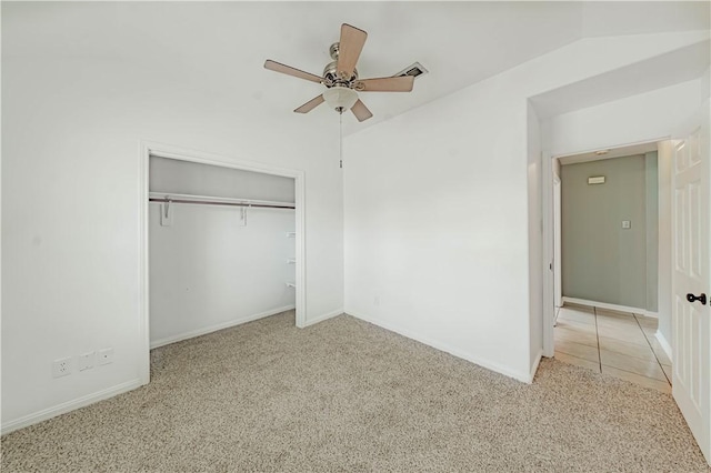 unfurnished bedroom with carpet floors, a closet, vaulted ceiling, and baseboards