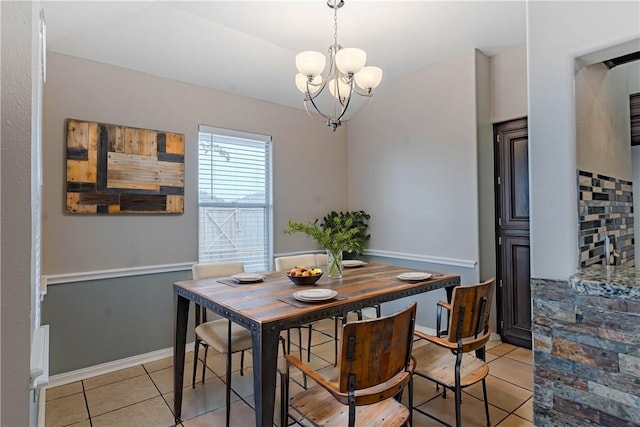 dining space with light tile patterned floors, baseboards, and an inviting chandelier