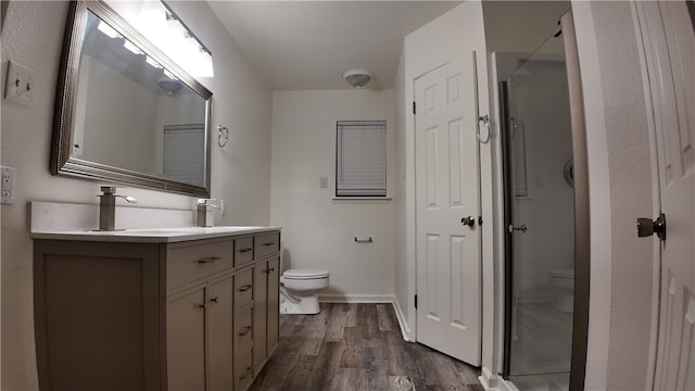 bathroom with wood-type flooring, vanity, and toilet