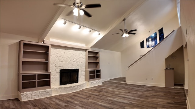 unfurnished living room featuring ceiling fan, rail lighting, dark hardwood / wood-style flooring, high vaulted ceiling, and a fireplace