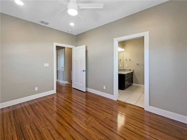 unfurnished bedroom with light hardwood / wood-style floors, ceiling fan, and ensuite bath