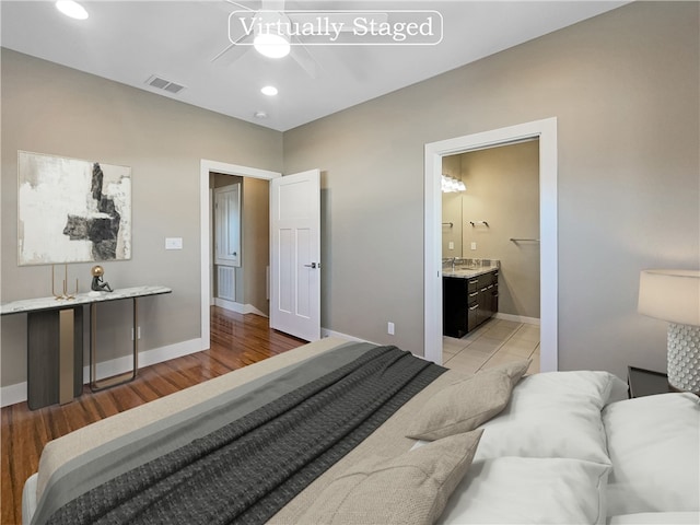 bedroom featuring light hardwood / wood-style floors, ceiling fan, and ensuite bathroom