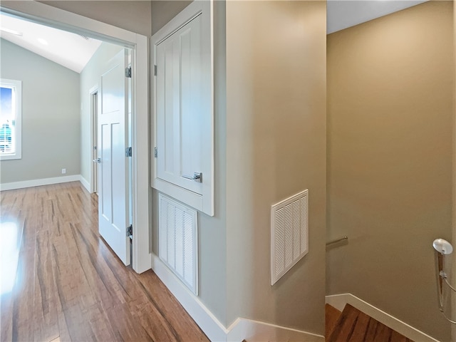 hallway featuring light wood-type flooring and lofted ceiling