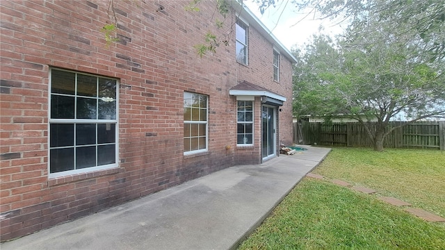2906 Alice Ln, Kingsville, TX 78363 - view of side of home with a lawn, brick siding, fence, and a patio