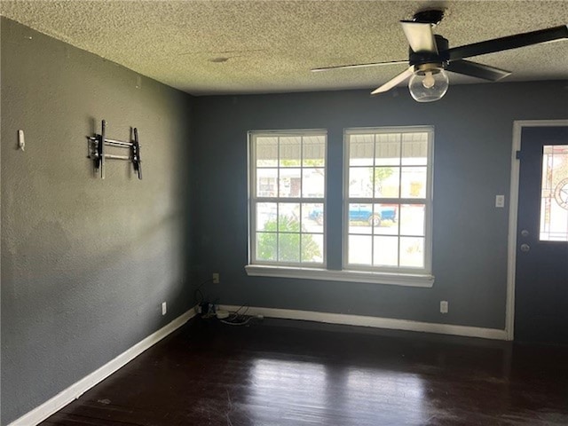 unfurnished room featuring dark hardwood / wood-style flooring, a textured ceiling, and ceiling fan