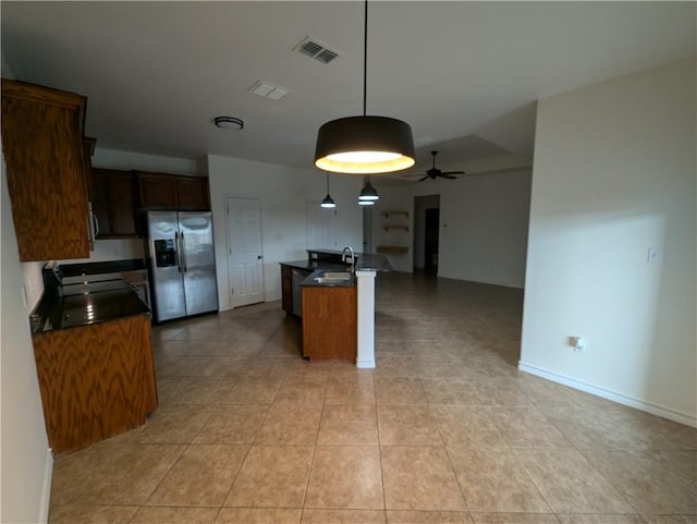 2905 Dante Dr, Corpus Christi, TX 78415 - kitchen featuring stainless steel appliances, dark countertops, ceiling fan, light tile patterned flooring, and a center island with sink